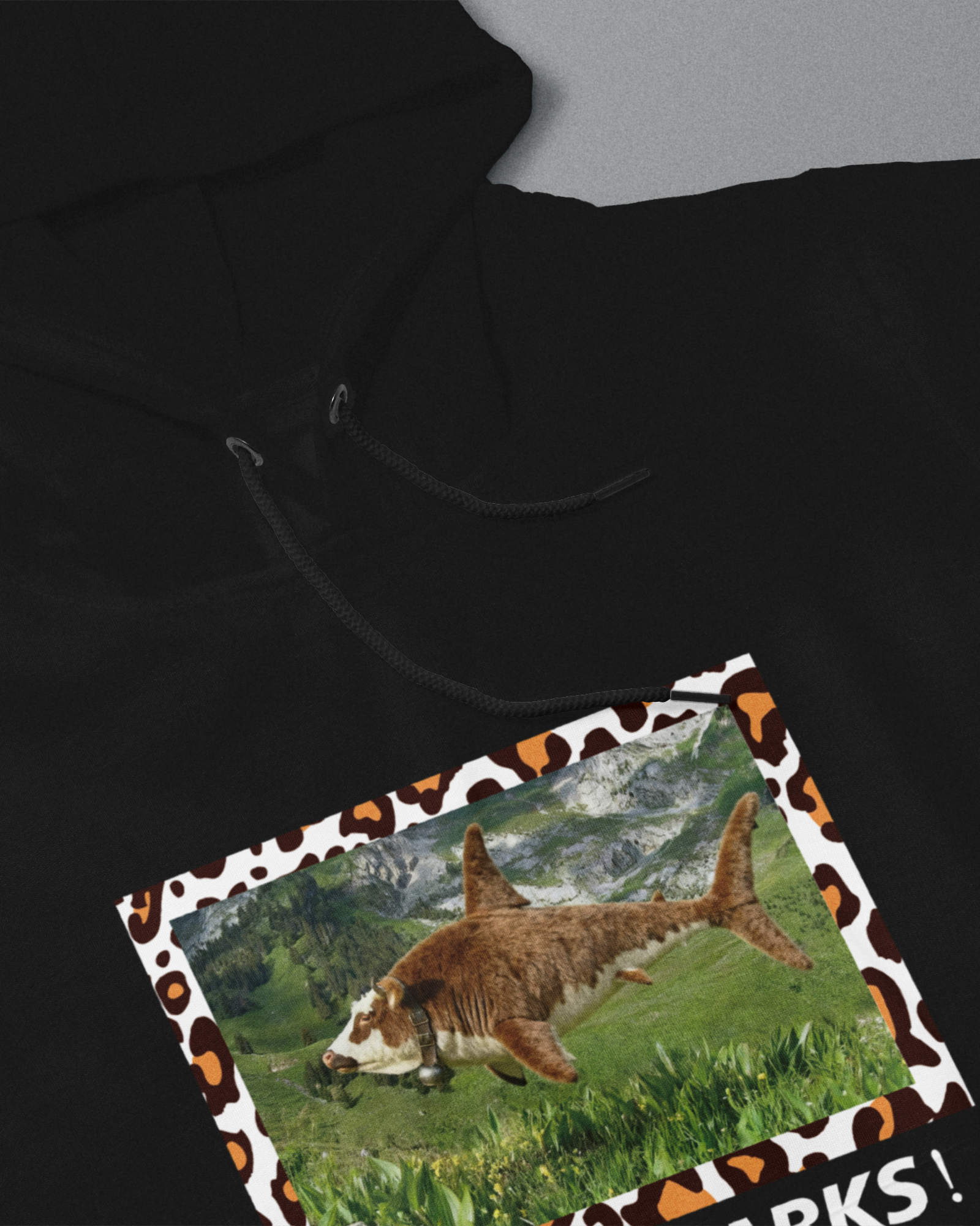 Black hoodie with a shark design on a gray background