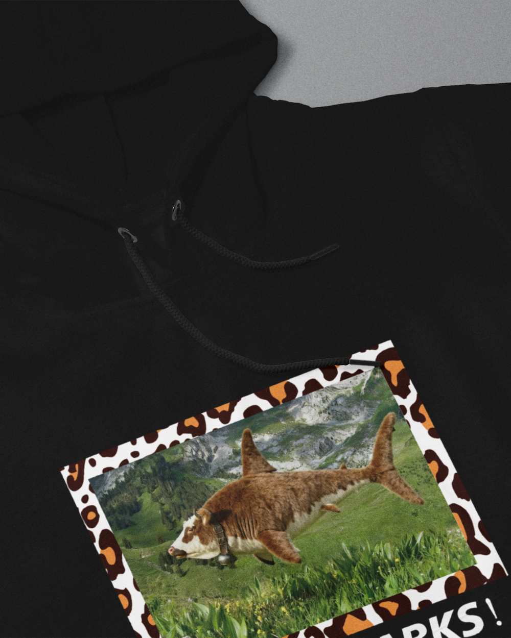 Black hoodie with a shark design on a gray background